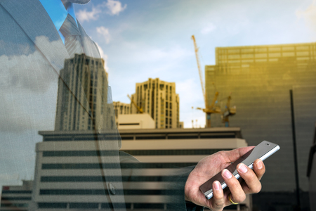 Young businessman using a smart phone to run his business.の写真素材