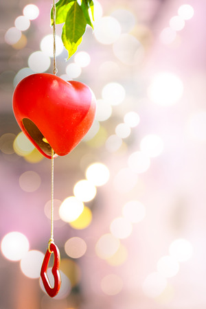 Heart-shaped bell hanging on the tree for Valentine's Day.の写真素材