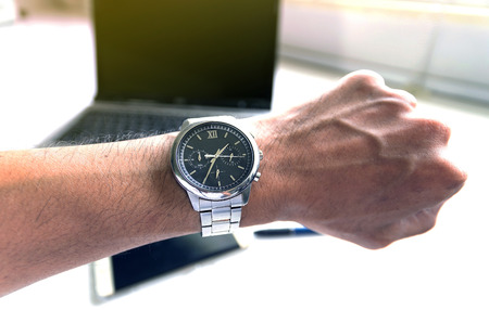 Businessman looking at his wristwatch, it was time to work yet.の写真素材