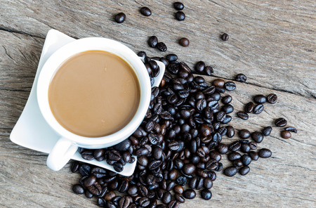 Coffee cup and coffee beans on old wooden background.の写真素材