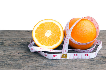 Closeup ofmeasuring tape and oranges  on a wooden floor.の写真素材