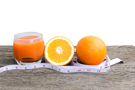 Closeup of orange juice and oranges  on a wooden floor.の写真素材
