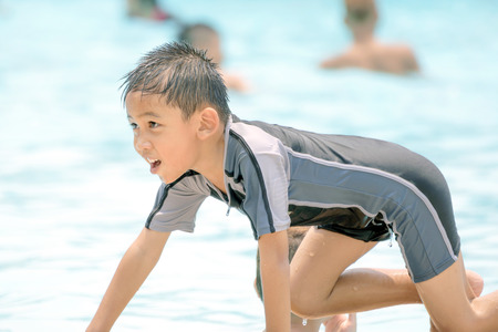 Asian boy in swimwear, swimming fun in the pool.の写真素材