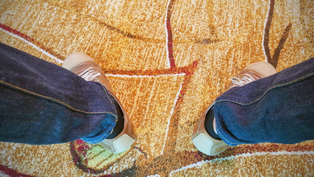 Two legs of the men wore blue jeans statements and brown leather shoes.