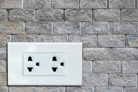 AC power plug on the vintage brick wall.