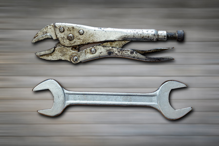 Locking Pliers and wrench on the blurred brick wall texture background concept and background for labor days.の写真素材