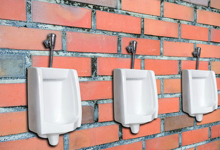 Urinal or chamber pot for men on the brick wall in the mens toilet.の写真素材
