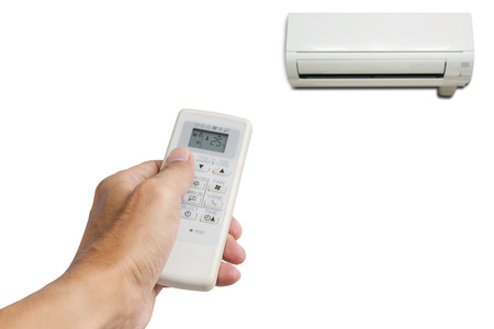 Hand holding the remote control to control the air conditioning isolated on white background.の写真素材