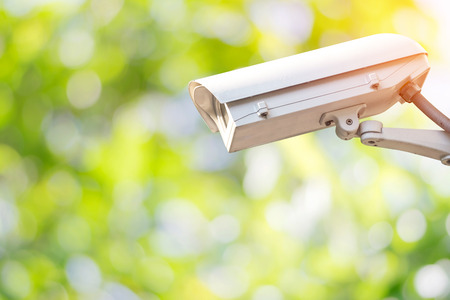 Closeup CCTV or surveillance camera in the garden with colorful green nature background.の写真素材