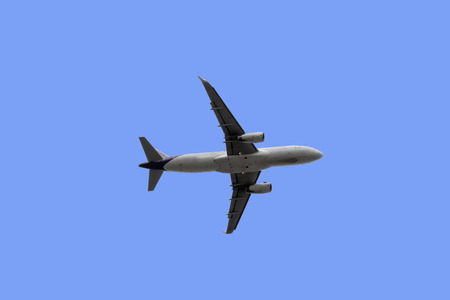 Closeup of the below of the plane that was flying up isolated on blue background.