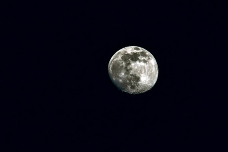 Closeup of the full moon on the black sky.