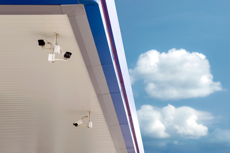 Closeup CCTV security surveillance cameras on the roof with blue sky background.の写真素材
