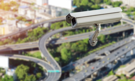 CCTV security camera isolated on blurred cityscape background.の写真素材