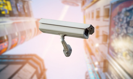 CCTV security camera isolated on blurred cityscape background.