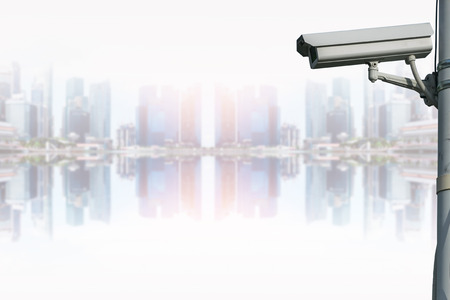 CCTV security camera isolated on blurred cityscape background.の写真素材
