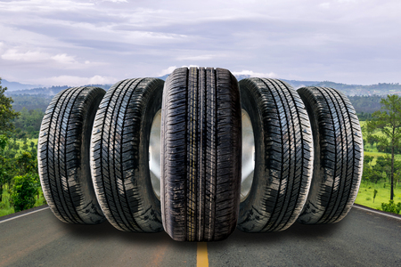 Car tires in row on the street with the forest background.の写真素材