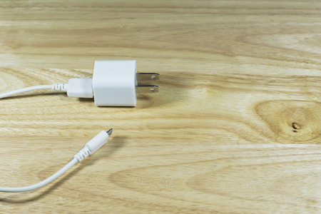 USB cable power adapter on wooden background.の写真素材