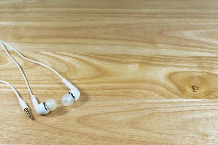 Headphone or earphone  on wooden background.の写真素材