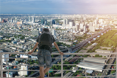 Backpacker standing and looking at to the skyscraper of the city.の写真素材