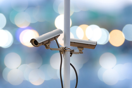 Closeup CCTV camera on colorful lighting background.