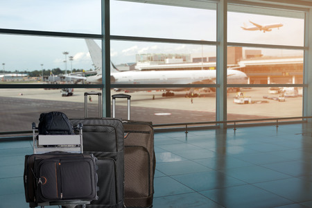 Closeup group of luggage in the airport terminal with the blurred airport runway  background.の写真素材