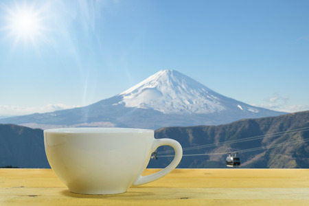 Close up of the white coffee mug on a wooden floor with the Mount Fuji background.の写真素材