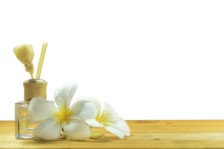 Bottle-conditioned with plumeria on the wooden floor on white background.の写真素材