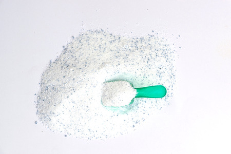 Closeup of washing powder texture background with plastic spoon on white background.の写真素材