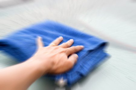Wipe the rain drops on the roof of the car with a microfiber cloth.の写真素材