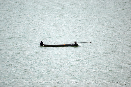 Freshwater fishermen on small boat are fishing in a river.の写真素材