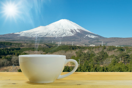 Close up of the white coffee mug on a wooden floor with the Mount Fuji background.の写真素材