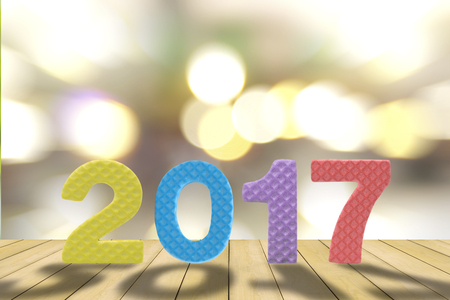 2017 figures on the wooden floor with bokeh of lighting background for news year.の写真素材