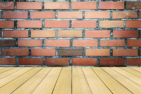 Wooden floor with colorful vintage brick wall background.の写真素材