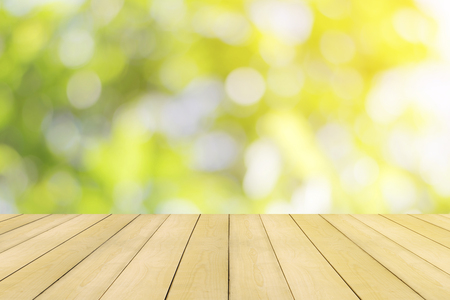 Wooden floor with colorful green nature bokeh background.の写真素材