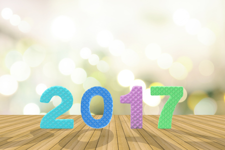 2017 figures on the wooden floor with bokeh of lighting background for news year.の写真素材