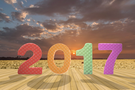 2017 figures on the wooden floor with beautiful sunset at the river background for news year.の写真素材