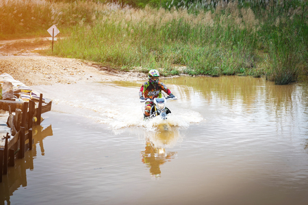 Ratchaburi,Thailand -Dec 4,2016: Motocross is trying to drive across the river to a depth of one meter in the wild.のeditorial素材