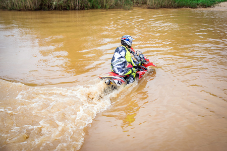 Ratchaburi,Thailand -Dec 4,2016: Motocross is trying to drive across the river to a depth of one meter in the wild.のeditorial素材