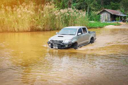 Ratchaburi,Thailand -Dec 4,2016: Four-wheel drive pickup truck were wading across the river in the forest.のeditorial素材