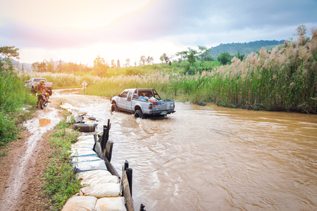 Ratchaburi,Thailand -Dec 4,2016: Four-wheel drive pickup truck were wading across the river in the forest.のeditorial素材