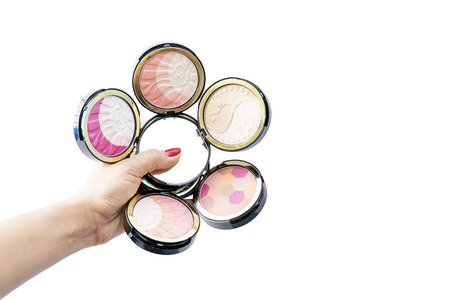 Closeup group of powder cosmetics in hand isolated on white background.の写真素材