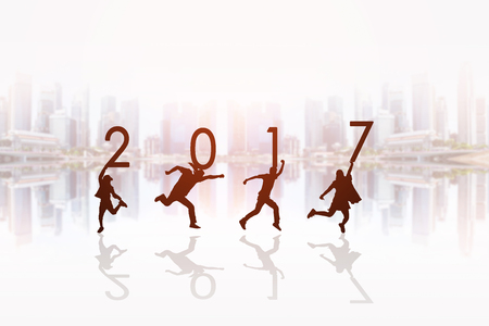 Silhouette of people holding numbers 2017 in front of the cityscape background, background for happy news years.の写真素材