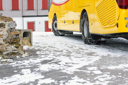 Put chains on the wheels of a bus in order to be able to run on the road is covered with snow in...
