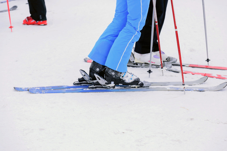 Closeup to the foot of the skier wearing ski on the snow.の写真素材