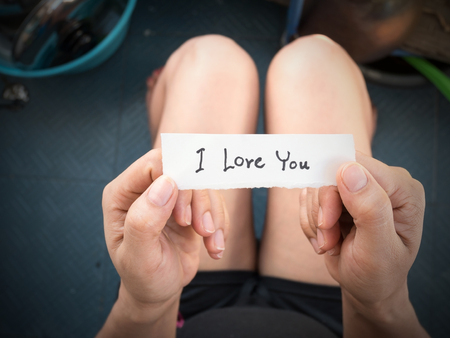 Woman's hand holding a paper with the message I received from her lover on Valentine's Day.の写真素材