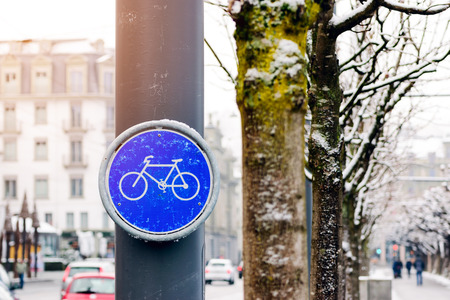 Bike lane signs mounted on utility poles in the city center.