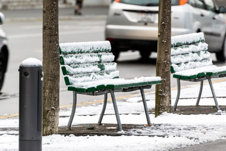 Empty chairs covered with snow in winter, on a side street in the city of Lucerne.の写真素材