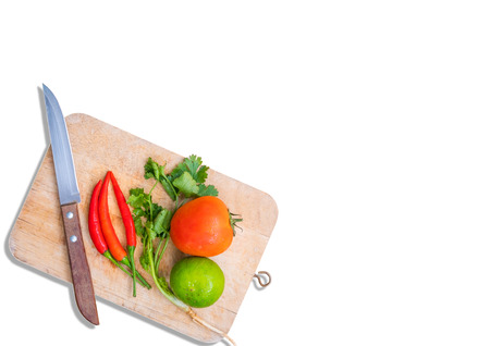 Knife and various kinds of fresh vegetables for cooking on a wooden chopping board isolated on white background,with clipping path.の写真素材