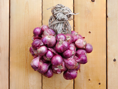 Closeup group of red onion on a wooden floor.の写真素材