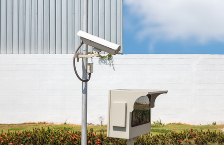 CCTV or surveillance camera  recording  important events and a guard house and property with the sunrise in the morning at the big city background.の写真素材